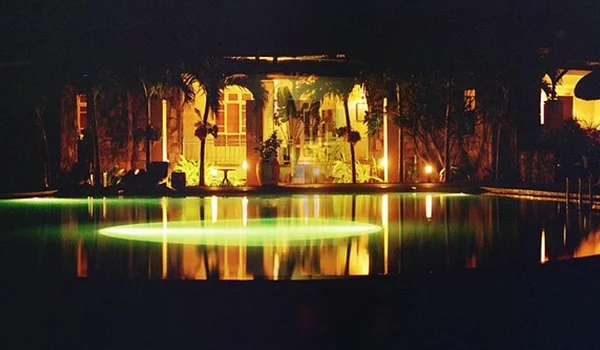 Foto noturna de um dos hotéis onde se observa o lobby e a piscina de Port Mathurin na Ilha Rodrigues.
