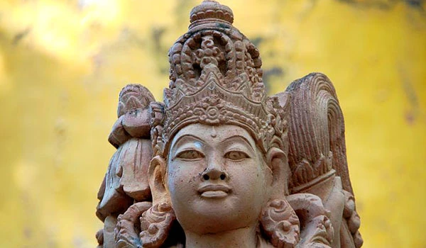 Estátua de um deus hindu antigo com detalhes intricados, localizada ao ar livre, simbolizando espiritualidade e cultura oriental. Casamento em Bali.