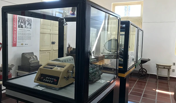 Exibição de máquinas históricas em vitrines de museu, destacando o papel da tecnologia na indústria. Dicas sobre o que fazer em Valinhos.