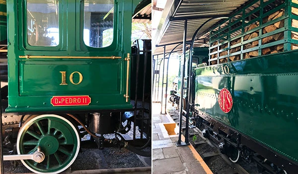Fotografia de uma locomotiva verde com detalhes em vermelho, marcada como D. Pedro II, destacando a cultura ferroviária brasileira.