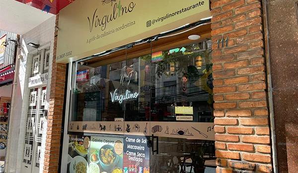Foto da entrada do Restaurante Virgulino onde se pode observar foto de pratos do cardápio como carne de sol entre outros.
