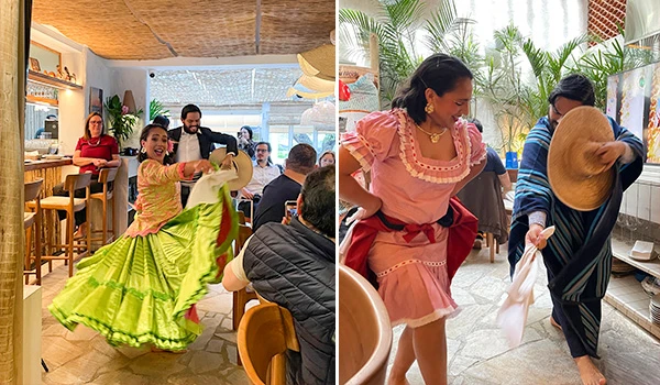 Dança tradicional mexicana com mulher vestida com saia vibrante azul e rosa em restaurante, enquanto outras pessoas apreciam a apresentação e a cultura.