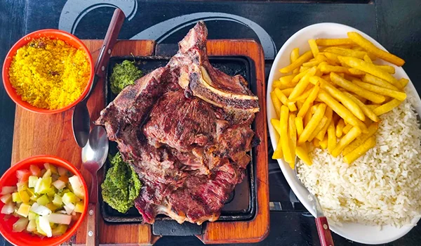 Foto de um prato com carne, arroz, batata, salada e farofa no bar Esquina do Fuad durante a Copa do Mundo em SP.