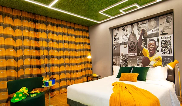 Foto de um apartamento do Hotel Pullman, totalmente temático sobre assistir jogos da Copa do Mundo em SP, com painel com Pelé na cabeceira.