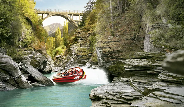 Foto de um barco stopover fazendo manobras radicais em um rio entre montanhas na Lua de Mel na Nova Zelândia.