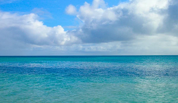 Foto de mar azul e céu com nuvens no Oceano Pacífico, na Viagem para as Ilhas Cook.
