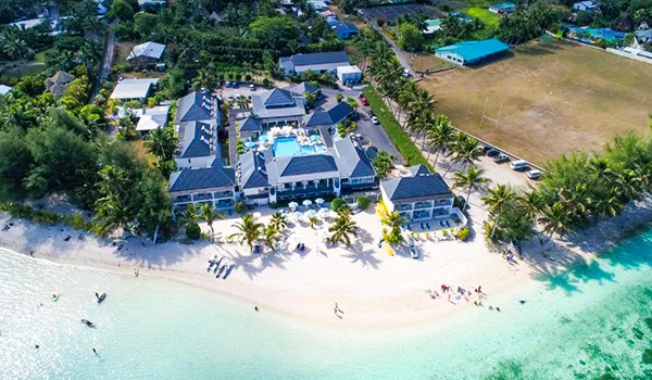 Foto aérea de um resort a beira mar de águas claras, na Viagem para as Ilhas Cook.