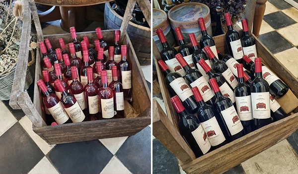 Vários pratos de vinho tinto em garrafas, organizados em uma caixa de madeira, prontos para venda ou consumo, destacando a variedade e qualidade.