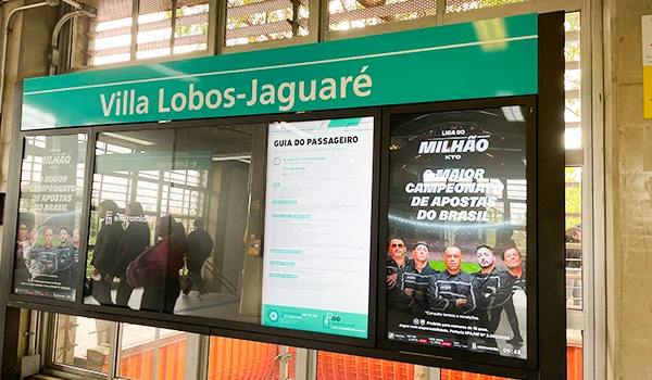 Informações e anúncios no ponto de ônibus na Vila Lobos-Jaguaré, São Paulo, incluindo um guia do passageiro e um cartaz de evento na rodoviária.