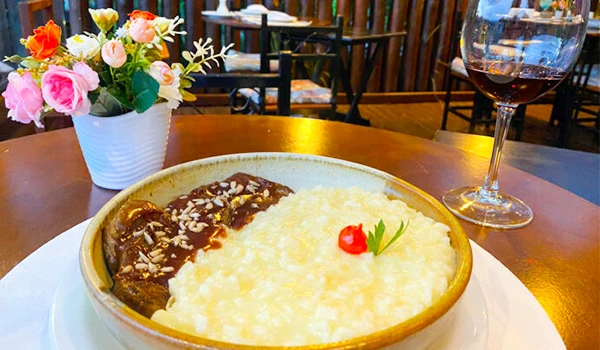 foto de um delicioso prato de arroz arbóreo, palmito, caldo de legumes, queijo parmesão e vinho do Porto, uma das dicas sobre onde comer na Serra da Mantiqueira.
