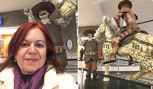 Deusa Rodrigues posando com uma escultura de cavaleiro e seu cavalo, feitos de materiais recicláveis em uma exposição. Dicas do Conjunto Nacional em São Paulo.