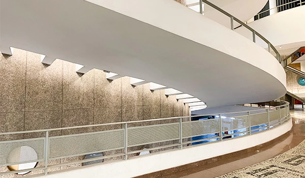 Vista interna de um espaço moderno com uma escada em espiral e iluminação suave, destacando a arquitetura contemporânea e minimalista. Dicas do Conjunto Nacional em São Paulo.