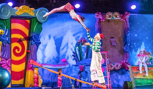 Foto bem colorida de 2 acrobátas no Cirque du Soleil, fazendo uma performance.