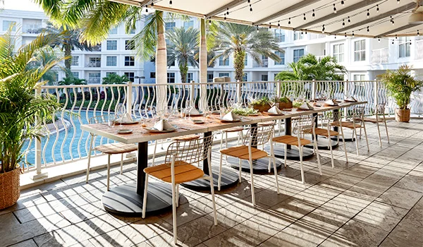 Foto de um restaurante com vista para a piscina tendo prédios ao redor. Onde ficar em Orlando.