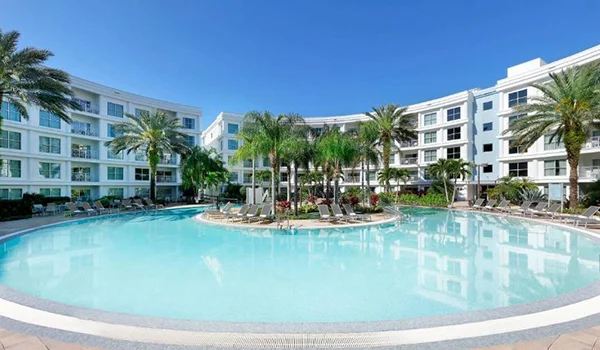 Foto do Hotel Meliá Celebration com três prédios e uma piscina com coqueiros ao meio. Onde ficar em Orlando.