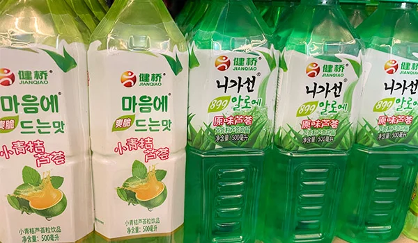 Foto de sucos asiáticos nas cores laranja e verde da loja Doces Neko.