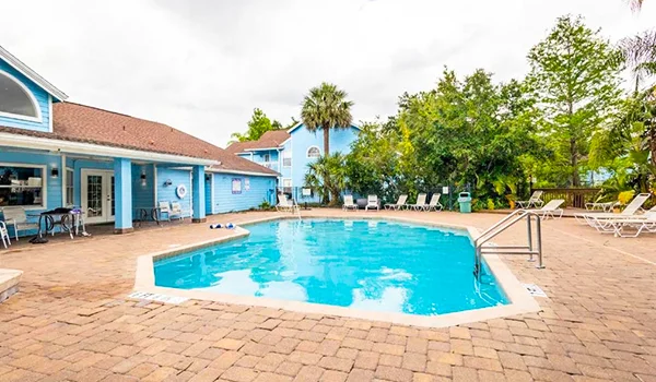 Foto de uma vila de hospedagem com corpo do hotel em azul e ao centro uma piscina cercada de plantas. Onde ficar em Orlando.