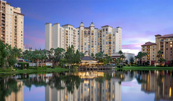 Foto dos prédios do Wyndham Resorts com lago ao meio e jardim com coqueiros. Onde ficar em Orlando.