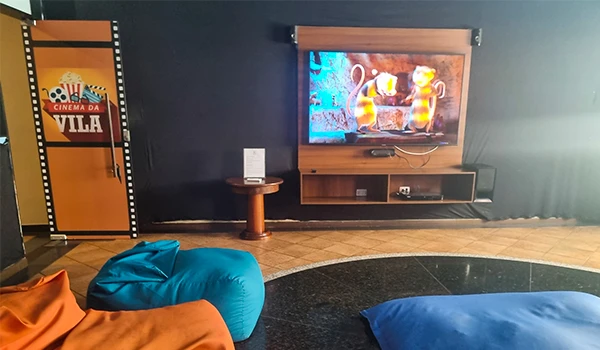 Sala de cinema em casa com TV exibindo filme de peixes dourados, poltronas confortáveis e decoração moderna, ideal para assistir filmes e séries em família.