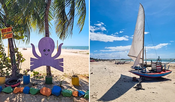 Cena de praia com decoração infantil de polvo feito de madeira, árvores de coqueiro, e barcos à vela em uma praia ensolarada com céu azul claro.