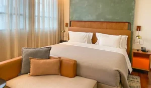 Foto do quarto do hotel Canopy Hilton, com cama e sofá.