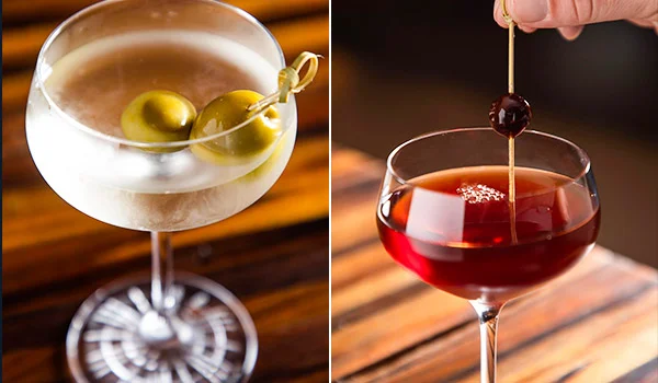 Foto de dois drinks, sendo um claro com azeitona e outro escuro, no hotel.