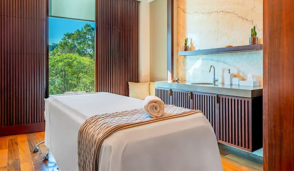 Foto da sala de massagem com janela onde se observa árvores no hotel Marriott.