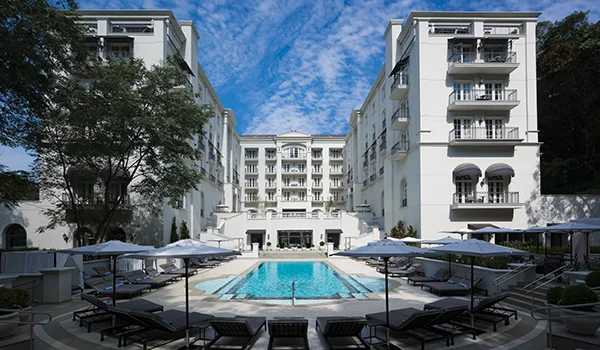 Foto do Hotel Palácio Tangara, uma construção branca imponente, com piscina ao centro. Um dos hotéis mais caros de SP.