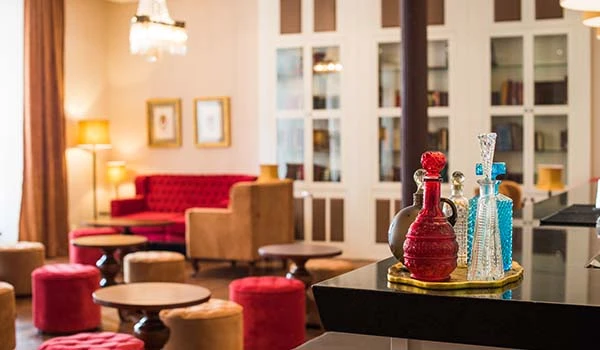 Sala de estar elegante com decoração sofisticada, poltronas vermelhas e mesa de centro, ideal para momentos de convivência e relaxamento em ambiente acolhedor.