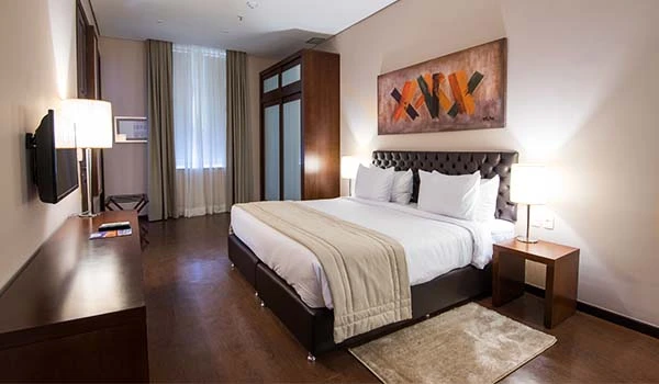 Quarto de hotel com cama confortável, decoração elegante e iluminação acolhedora, ideal para uma estadia de lazer ou negócios. Hotel Histórico no Rio de Janeiro.