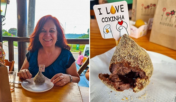 Deusa Rodrigues segurando uma coxinha em um prato, com uma plaquinha escrita "I LOVE COXINHA" ao lado da iguaria compartilhando um momento de alegria.