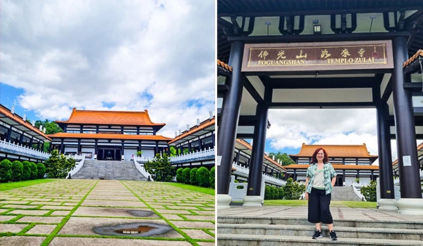 Imagem do Templo Zu Lai em Cotia com arquitetura tradicional chinesa e uma pessoa posando na entrada do templo, cercada por jardins bem cuidados e um céu parcialmente nublado.