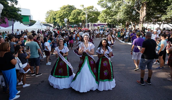 39 Festa da Uva e 10ª Expo Vinhos Rainha e Princesas, em Jundiaí, vestidas com trajes tradicionais em um evento festivo, cercadas por uma multidão animada. Uma das Festas Típicas do Interior.