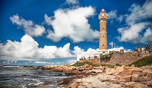 Imagem do farol parcialmente nublado e mar calmo ao fundo. Cenário praiano tranquilo e bonito. José Ignacio paradores e restaurantes.