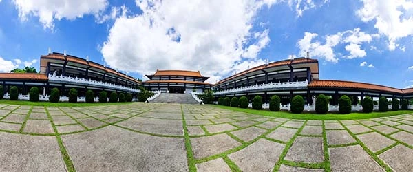 Vista panorâmica do templo budista com arquitetura tradicional e céu azul em um dia ensolarado, ideal para relaxamento e meditação.