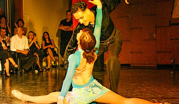Dançarinos fazendo uma performance artística em palco com público assistindo ao fundo. Shjws de Tango de Buenos Aires no Viejo Armacén.