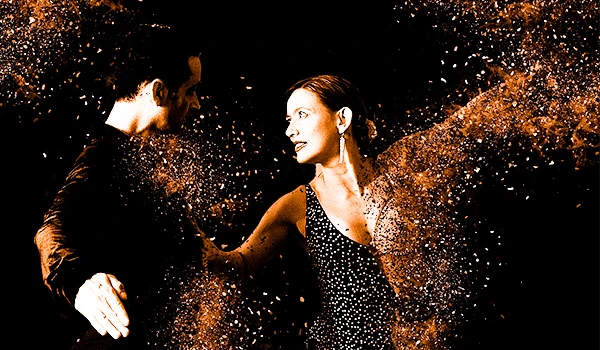 Casal dançando no show de tango em Buenos Aires com efeito de partículas de pó dourado ao redor, mostrando energia, paixão e conexão na pista de dança, iluminação vibrante.