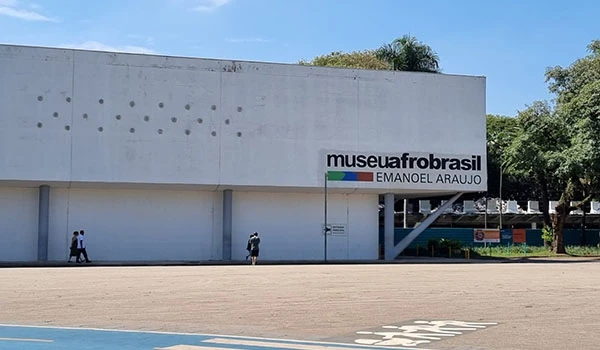 Imagem do Museu Afro Brasil localizado no Parque Ibirapuera, destacando sua fachada moderna com o nome do museu e uma área de estacionamento ao redor.
