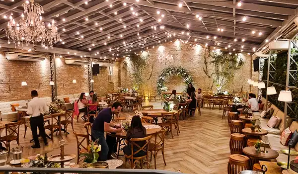 Ambiente sofisticado com iluminação aconchegante, mesa decorada e clientes aproveitando o espaço Casa Quintal. Degustação de jantar, um dos eventos para casamento em São Paulo.