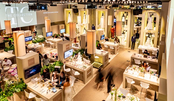 Imagem de um dos Eventos sobre casamento em São Paulo, apresentando diversos estandes com vestidos e acessórios, e visitantes interagindo em um ambiente iluminado. 