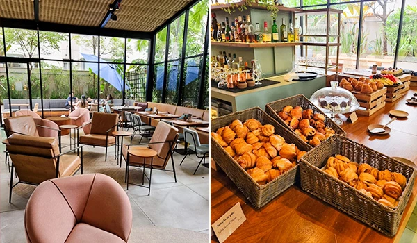 Imagem de um ambiente moderno e aconchegante com mesas e cadeiras, além de uma variedade de pães e doces em prateleiras, ideal para um café da manhã.