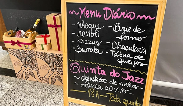 Quadro de menu diário com opções de comida e música ao vivo na Quinta do Jazz, incluindo pratos como nhoque, navioli, pizzas e burata, ideal para refeições e entretenimento. Mercado de Santo Amaro restaurantes.