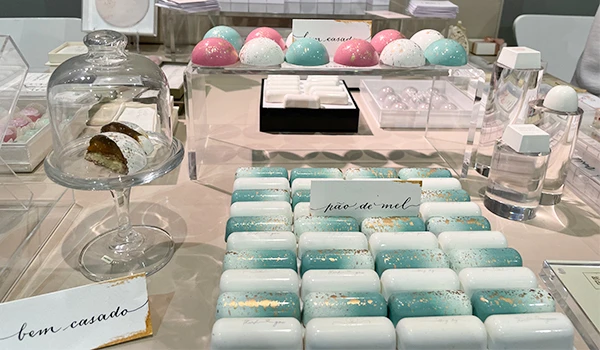 Imagens de doces finos em mesa de festa, incluindo bem-casado, pão de mel e outras delícias decoradas na cor verde e rosa, em um eventos para casamento em São Paulo.