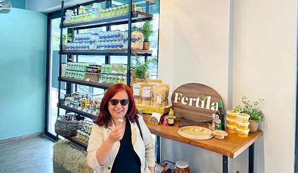 Deusa Rodrigues, em loja de produtos de fertilidade com prateleiras cheias de suplementos e vitaminas.