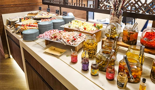 Buffet variado com saladas, pratos frios e conservas em um restaurante. Perfeito para quem busca opções saudáveis e saborosas na refeição.