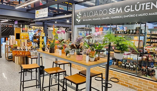 Imagem de uma loja de produtos sem glúten com variedade de alimentos e itens sustentáveis, destacando o ambiente organizado e acolhedor.