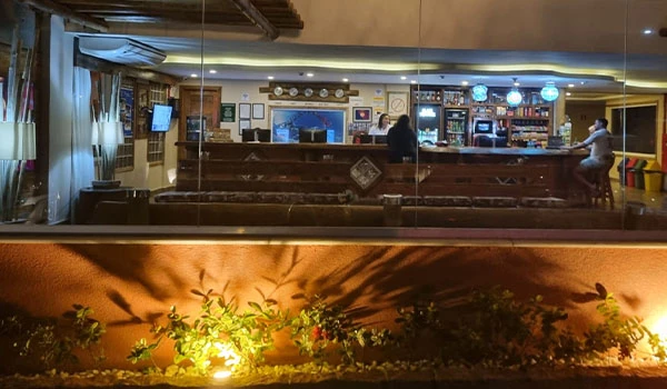 Imagem de um bar aconchegante com decoração moderna, iluminação suave, balcão de atendimento e ambiente confortável, ideal para socializar e relaxar.