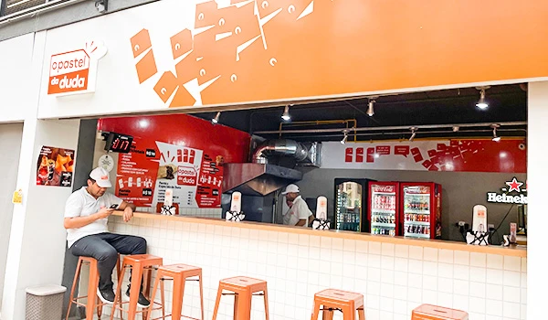 Interior de um ponto do Pastel da Duda, em um ambiente acolhedor e organizado.