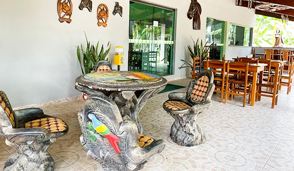 Seis cabeças de cavalo decorativas em madeira, esculpidas e pintadas em tons de marrom e preto, com detalhes em branco e arreios. As peças estão dispostas em uma parede branca, algumas com molduras em formato de ferradura.