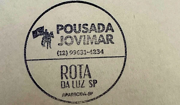 Carimbo circular da Pousada Jovimar, em Aparecida, São Paulo, com telefone para contato e identificação da Rota da Luz SP.